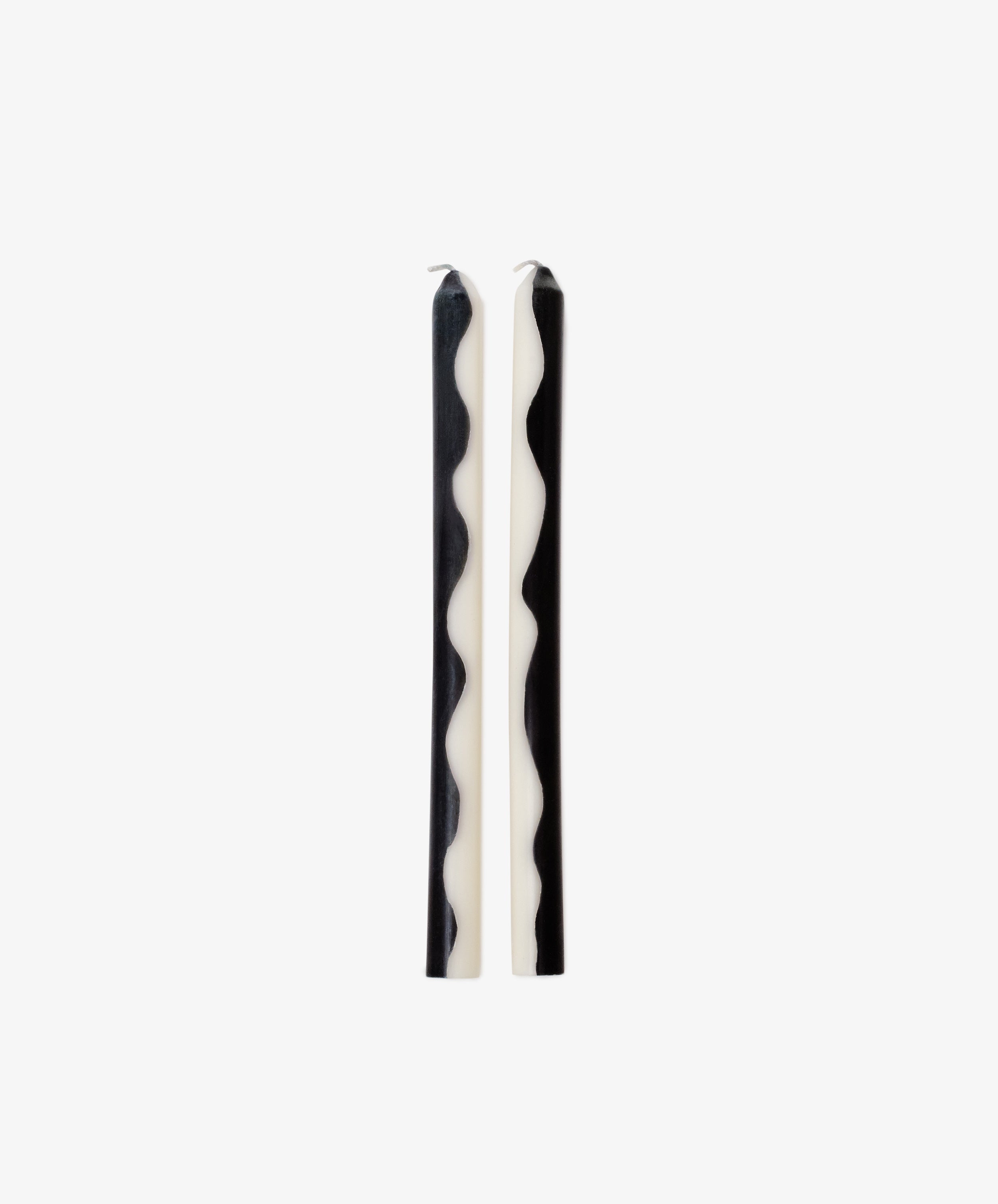 Two Twiglet Candles, featuring black and white wavy patterns, stand upright side by side on a plain white background, bringing a decorative flair to any space.