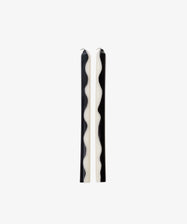 Two Twiglet Candles, featuring black and white wavy patterns, stand upright side by side on a plain white background, bringing a decorative flair to any space.