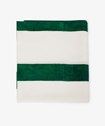 The Riga Tablecloth is an artisanal linen piece with wide horizontal green and white stripes on a plain background, neatly folded for display.