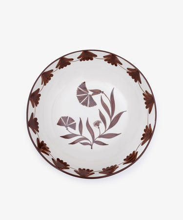 The Catalina Serving Bowl is a round ceramic piece from Portugal, featuring brown floral rim patterns and hand-painted flowers and leaves at the center on a white background.