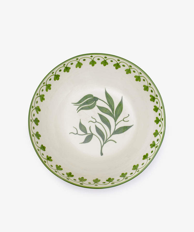 The Esmeralda Serving Bowl is a round, hand-painted ceramic bowl with a green floral center and a green patterned border on a white background.