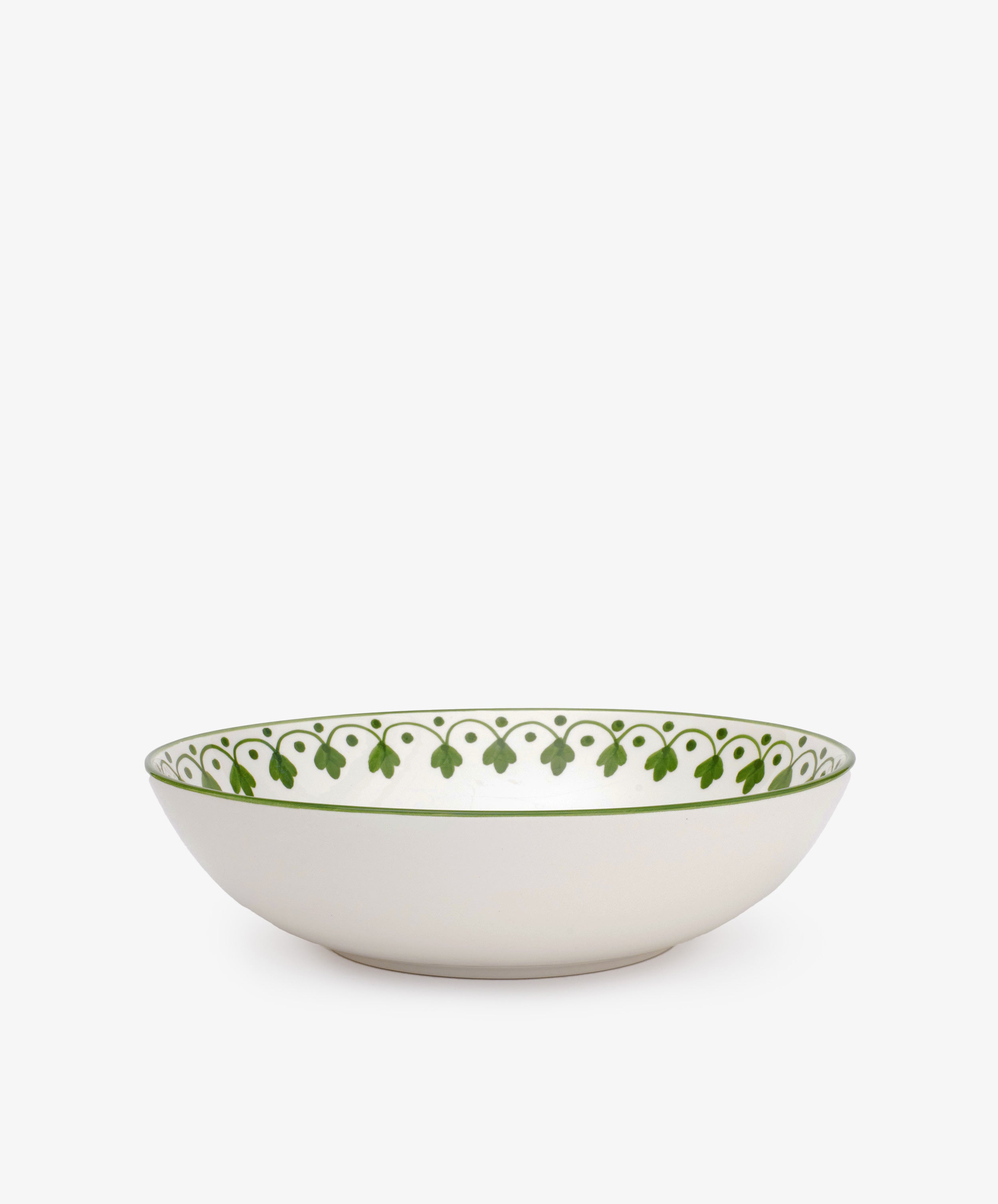 The Esmeralda Serving Bowl is a white hand-painted ceramic bowl featuring a green decorative pattern around the rim, shown on a plain white background.