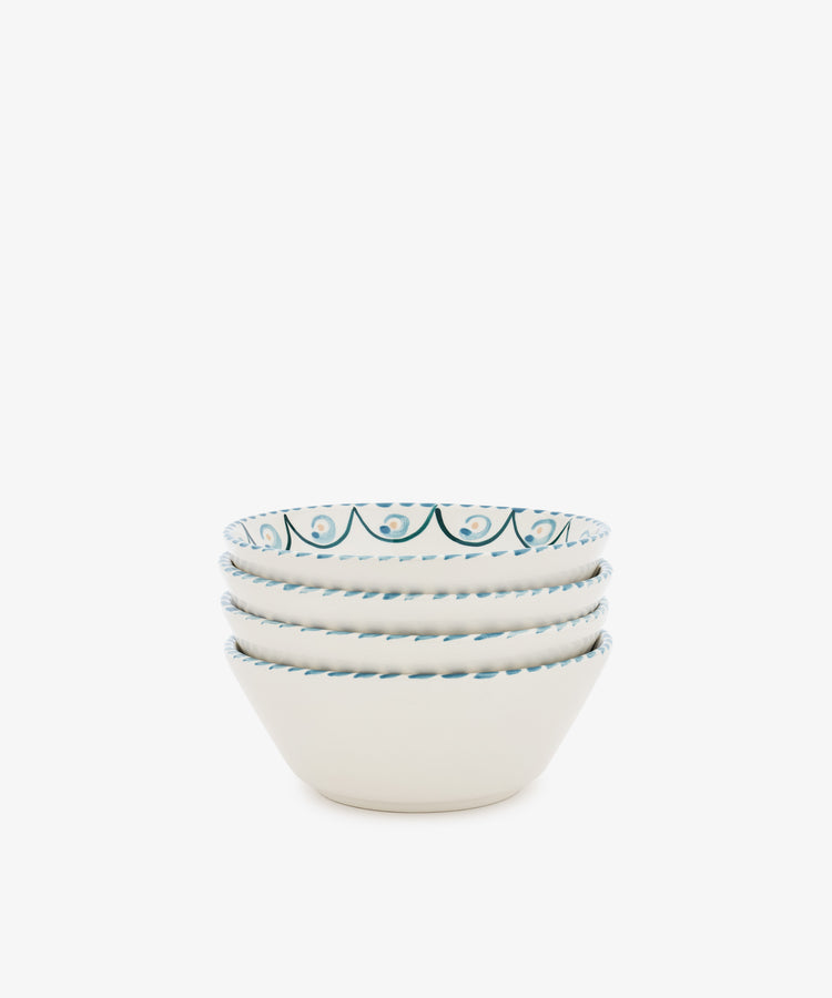 The Ottoline Cereal Bowl set includes four white ceramic bowls, each hand-painted with a blue decorative pattern inspired by Tess Newall, shown stacked together against a plain white background.