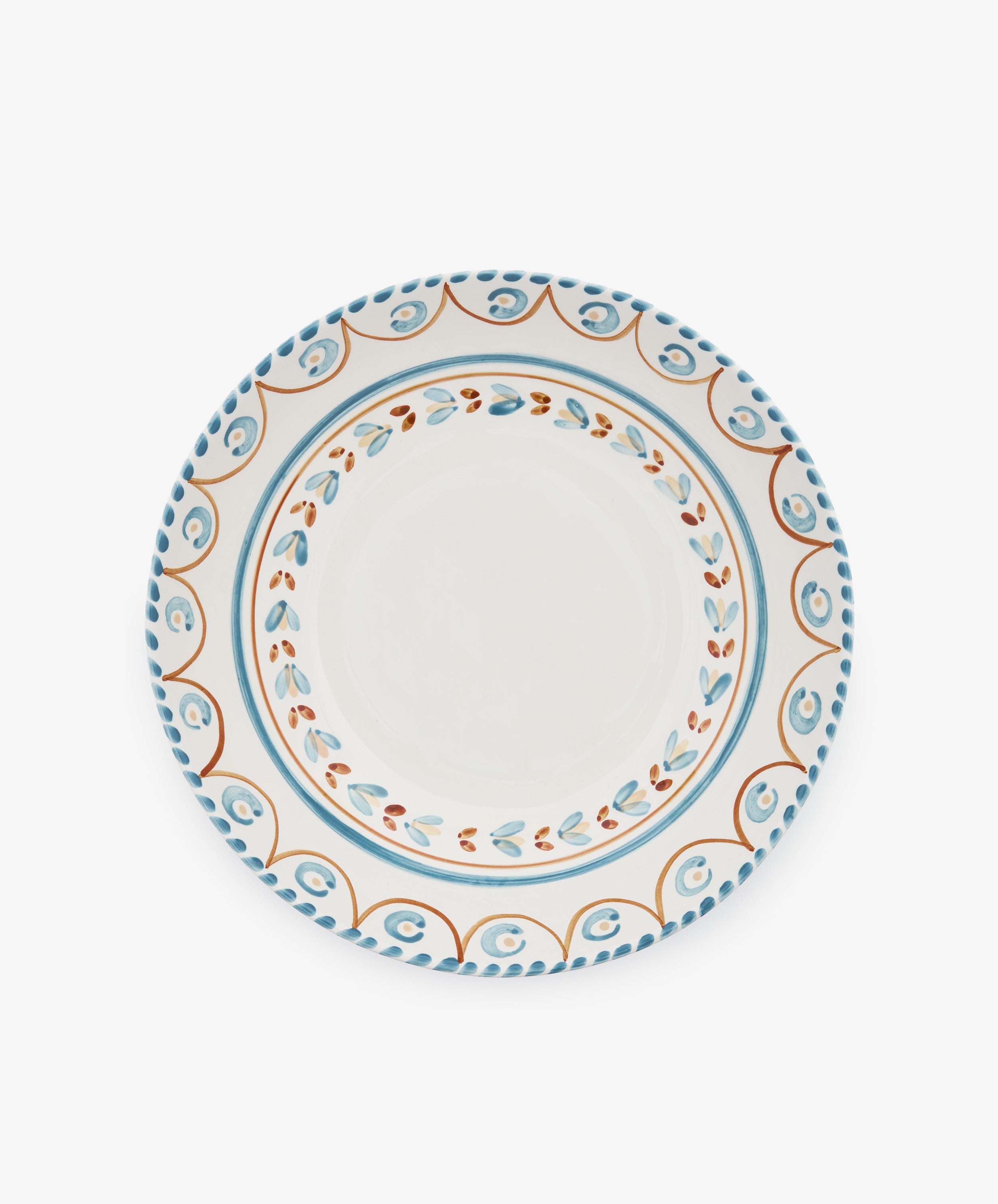 The Ottoline Serving Bowl is a round ceramic piece with a white center and blue, orange, and brown patterned borders inspired by Italian majolica.