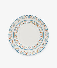 The Ottoline Serving Bowl is a round ceramic piece with a white center and blue, orange, and brown patterned borders inspired by Italian majolica.