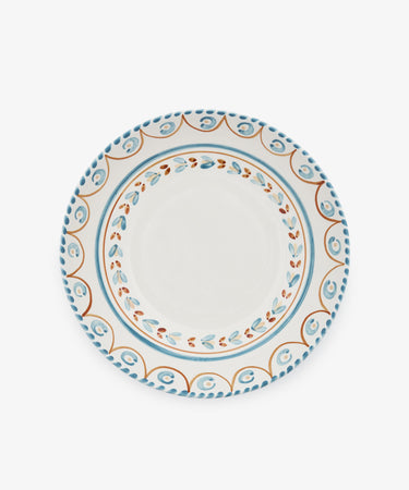 The Ottoline Serving Bowl is a round ceramic piece with a white center and blue, orange, and brown patterned borders inspired by Italian majolica.