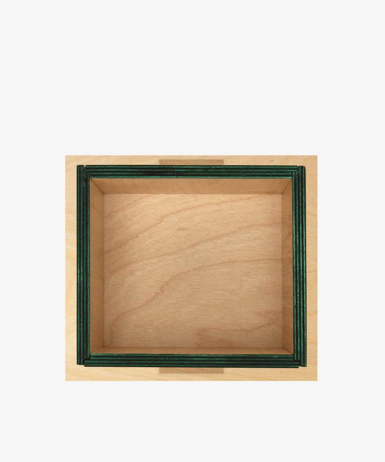 The Milo Keepsake Box is a square wooden modular box with green-trimmed edges, shown empty from above against a white background. From PORTA House of RoRo, it’s perfect as a puzzle treasure chest for your mementos.
