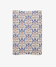 Arabesque Gift Wrap featuring a rectangular textile design with an ornate repeating pattern in red, blue, and beige on a cream background, showcasing symmetrical floral motifs and abstract Arabesque elements.