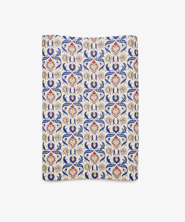 Arabesque Gift Wrap featuring a rectangular textile design with an ornate repeating pattern in red, blue, and beige on a cream background, showcasing symmetrical floral motifs and abstract Arabesque elements.