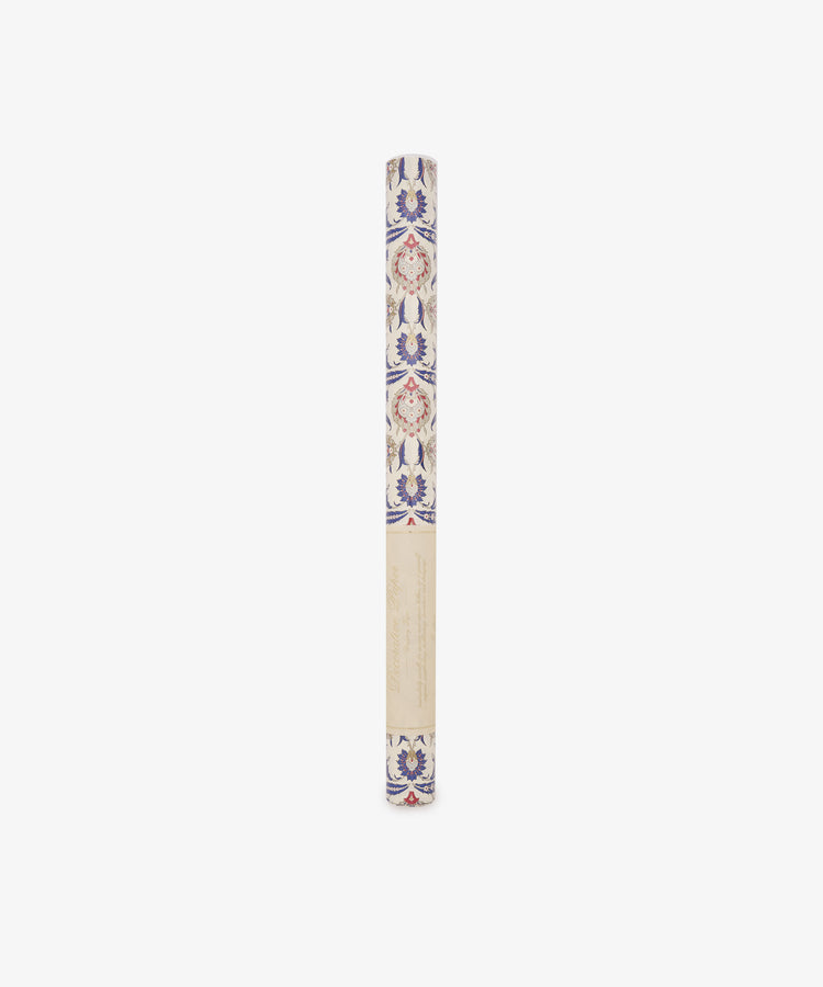 Arabesque Gift Wrap, a rolled sheet of decorative paper showcasing a sophisticated blue and red floral Arabesque pattern, is displayed vertically against a white background.