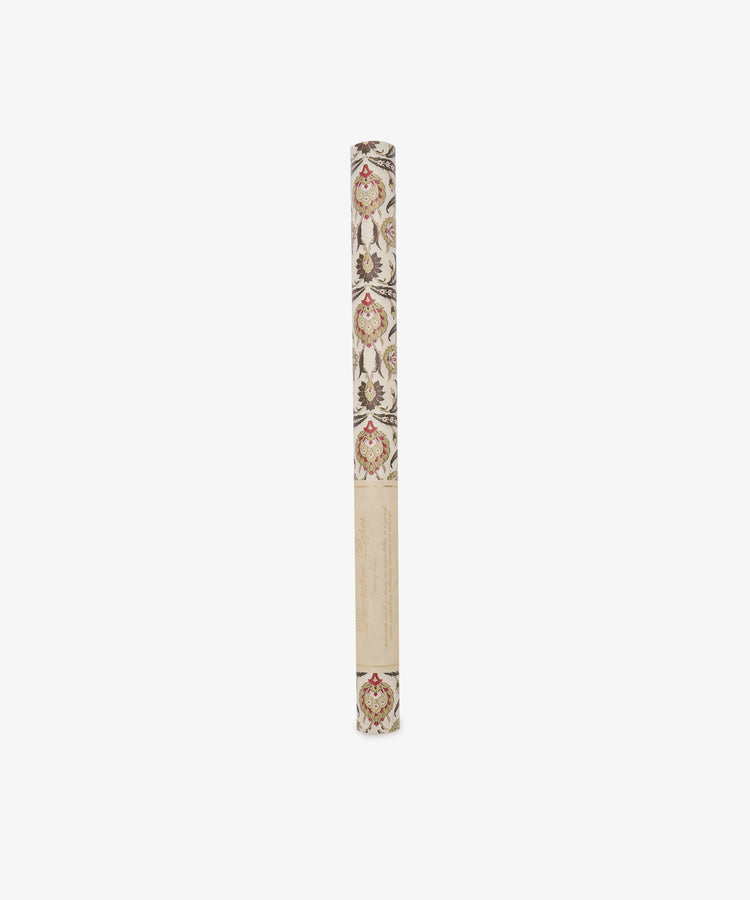 A rolled tube of Arabesque Gift Wrap, featuring elegant floral motifs and a leaf pattern in red, brown, and beige tones, displayed upright on a white background.