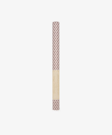 A rolled sheet of Lilies Gift Wrap featuring a red floral design, wrapped in a beige label, stands upright on a white background.