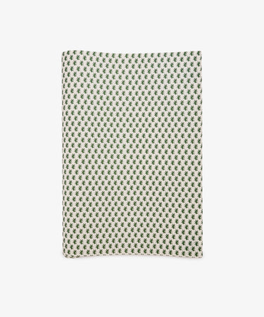 A sheet of Rampant Lions Gift Wrap featuring a repeating small green geometric floral pattern on a cream background is shown folded and displayed flat on a white surface.