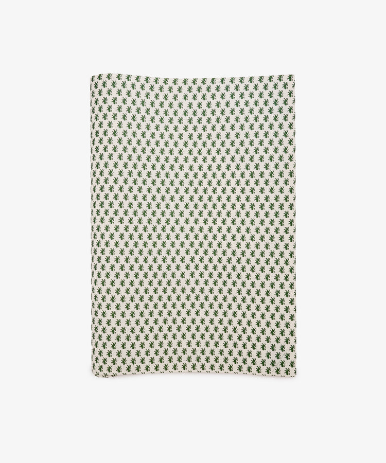 A sheet of Rampant Lions Gift Wrap featuring a repeating small green geometric floral pattern on a cream background is shown folded and displayed flat on a white surface.