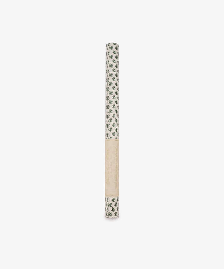 A roll of Rampant Lions Gift Wrap featuring a green botanical print on a subtle cream background, wrapped in a beige paper label and displayed against a plain white backdrop.