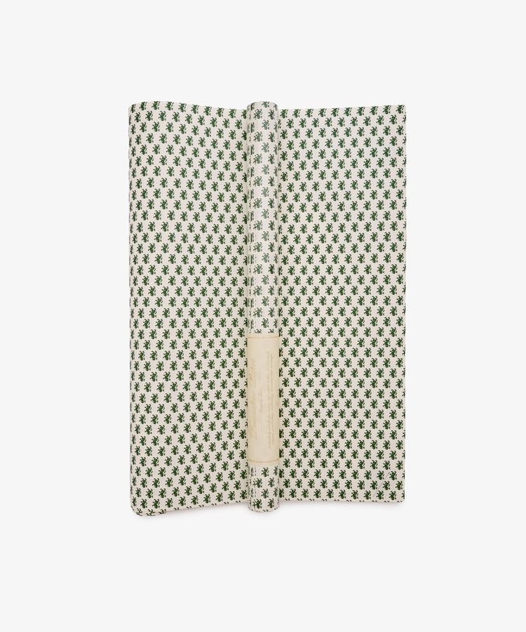 An open book featuring the “Rampant Lions Gift Wrap”—a green and white patterned cover reminiscent of elegant wrapping paper—with a blank white label on the spine, photographed against a white background.