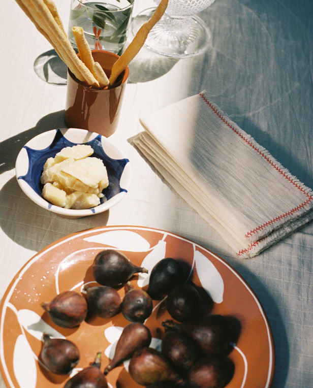 linen napkins blue bowl terra cotta plate with cheese figs and cracker sticks