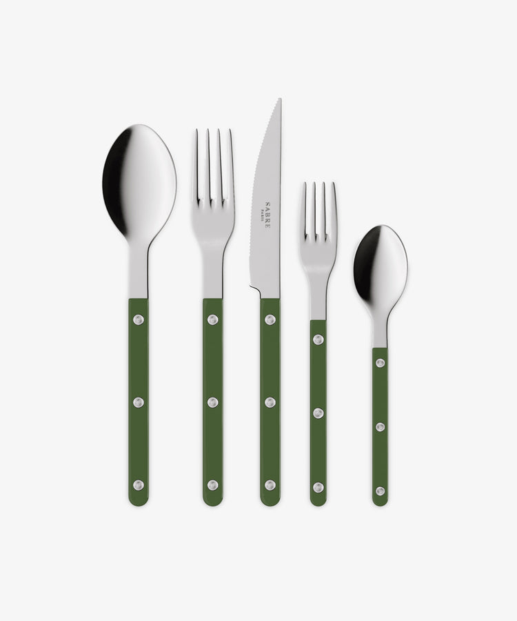 The Bistrot 5 Piece Cutlery Set features a tablespoon, dinner fork, knife, salad fork, and teaspoon with green handles and metal rivets, echoing classic French café style. They are arranged side by side on a white background.
