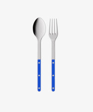 The Bistrot Serving Set, featuring a metal spoon and fork with blue handles and silver rivets, is displayed side by side on a plain white background.