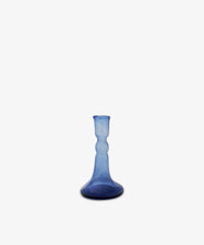 The Lucia candleholder is a small, blue glass piece with a flared base and narrow neck, ideal for taper candles, shown against a plain white background.