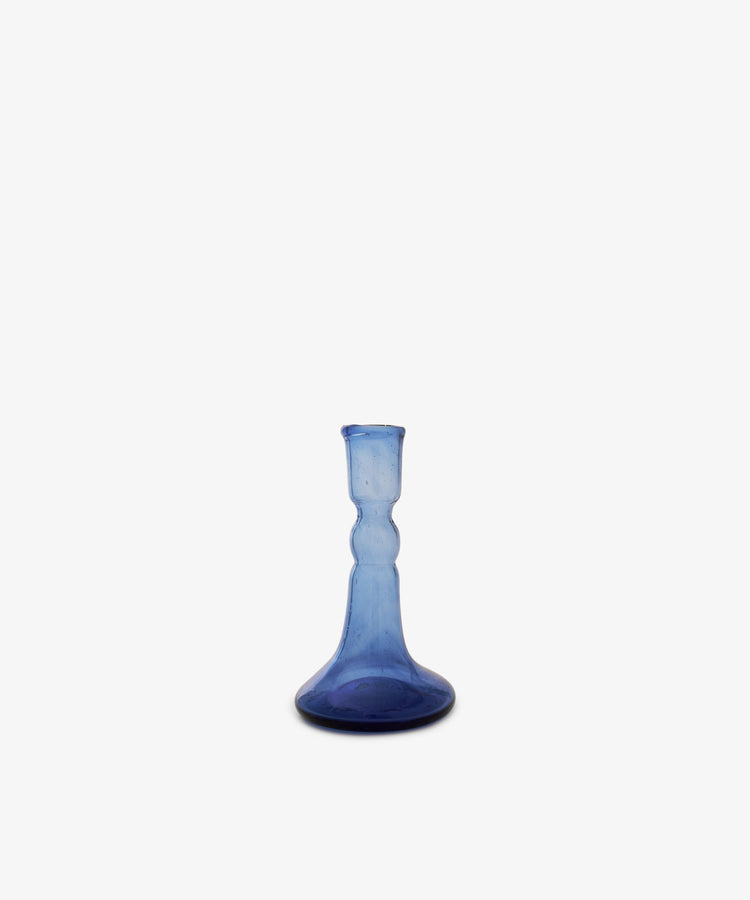 The Lucia candleholder is a small, blue glass piece with a flared base and narrow neck, ideal for taper candles, shown against a plain white background.