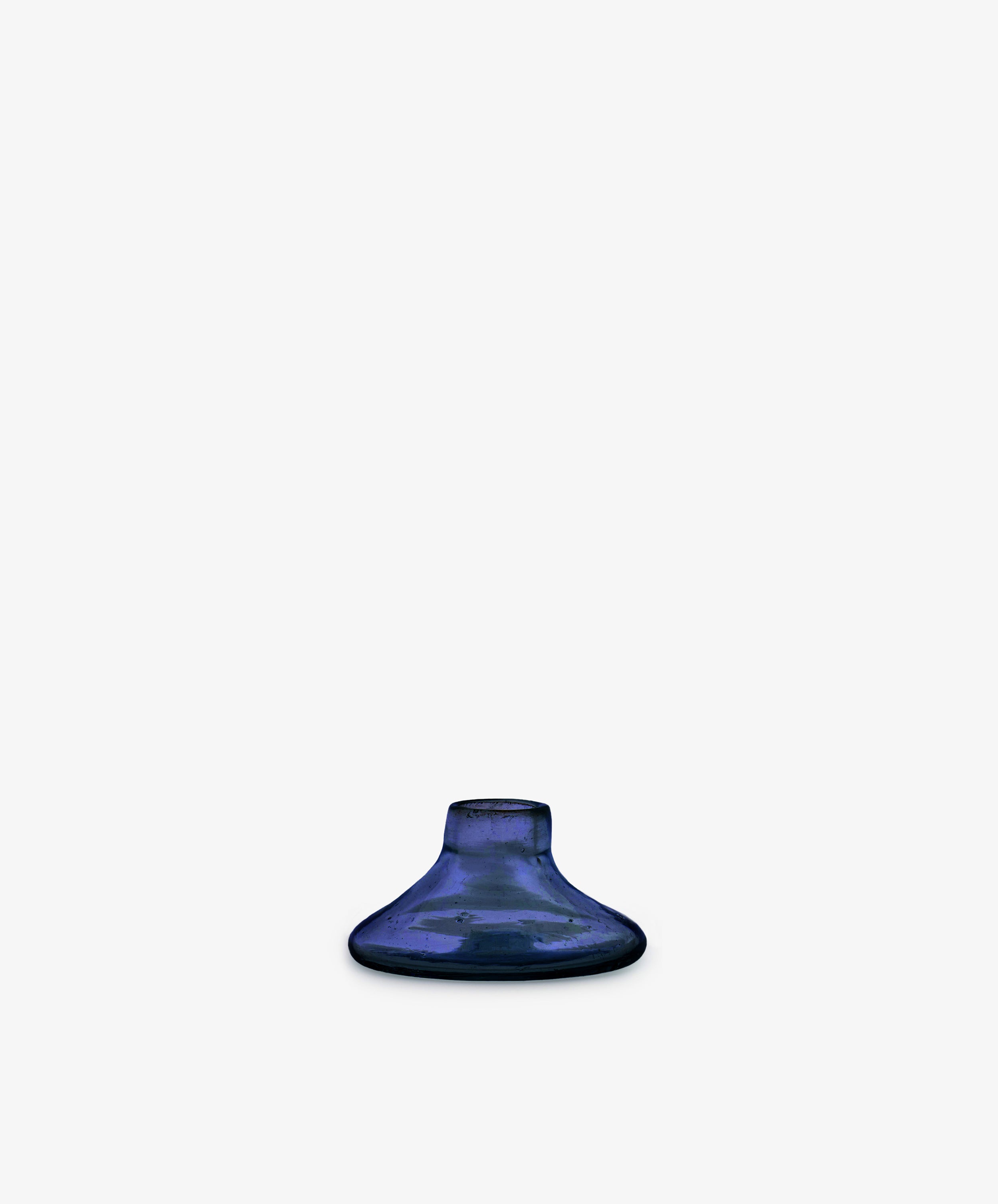 The Lucien candleholder, Small, is a handblown blue vase made from recycled glass in Morocco, featuring a small round shape with a wide base and narrow opening, shown centered on a plain white background.