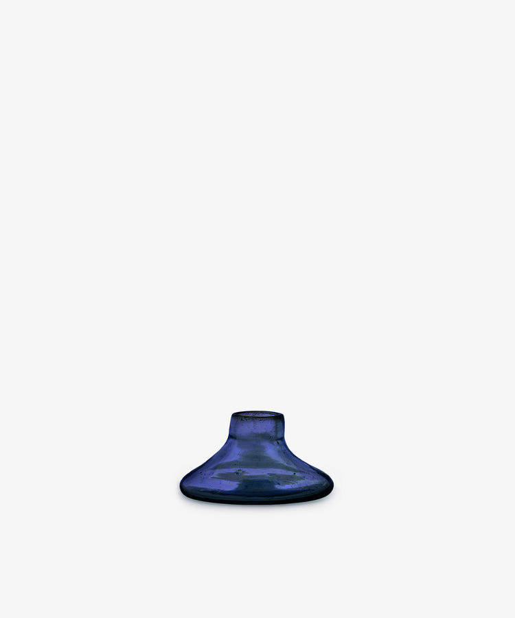 The Lucien candleholder, Small, is a handblown blue vase made from recycled glass in Morocco, featuring a small round shape with a wide base and narrow opening, shown centered on a plain white background.