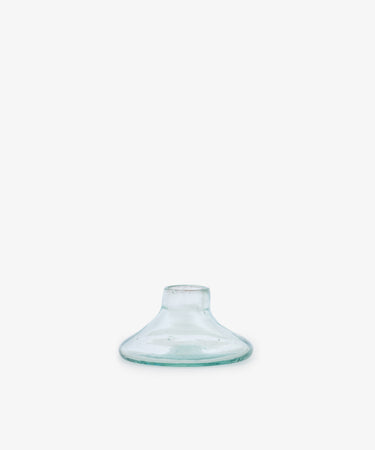 The Lucien candleholder, Large—a clear, flat-bottomed glass piece with a wide base and short neck, handblown in Morocco from recycled glass—is centered on a plain white background.