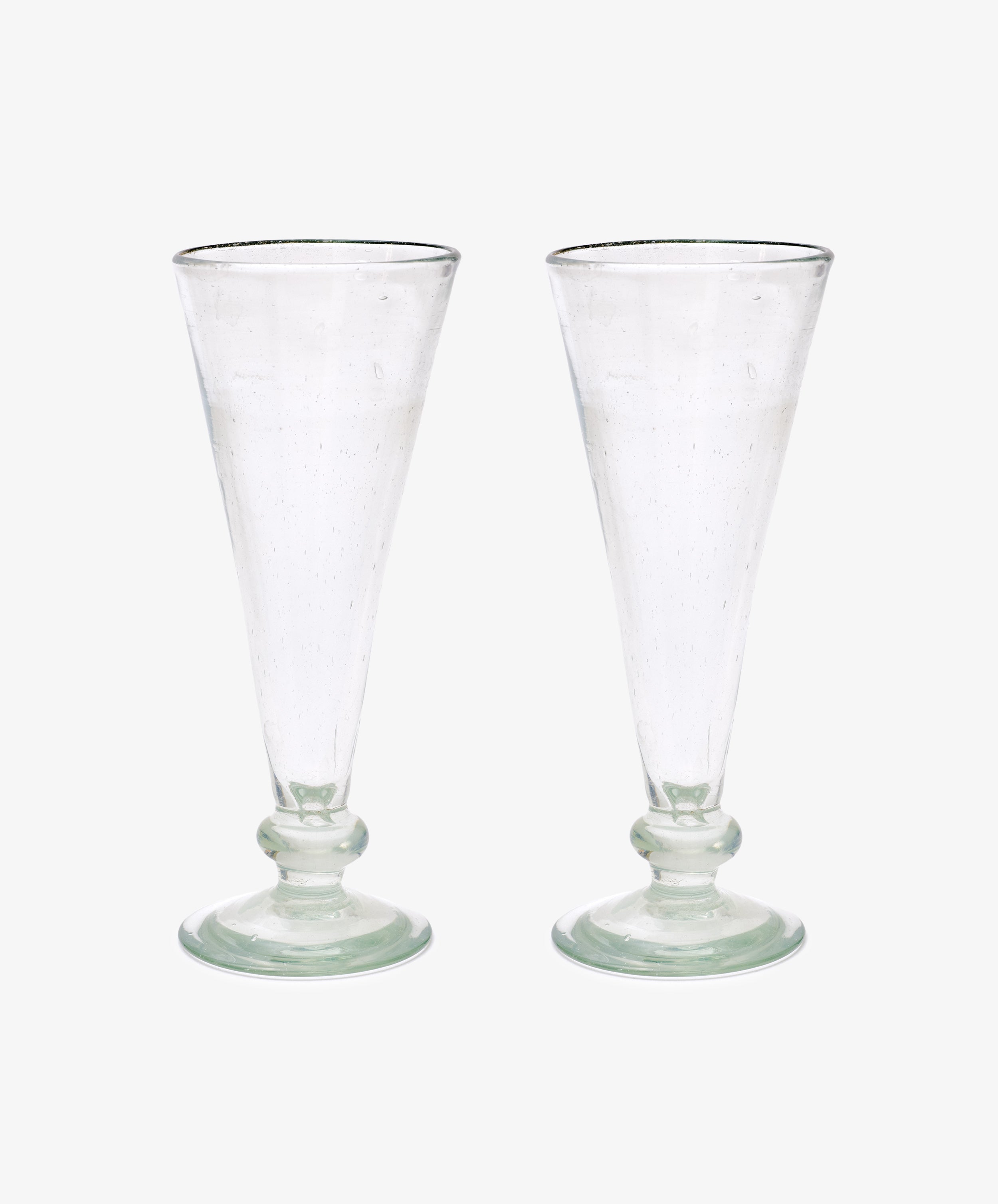 A set of six Elodie Champagne Glasses, featuring clear, tall handmade stems with round bases, are displayed side by side against a plain white background.