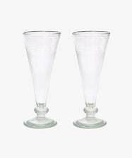 A set of six Elodie Champagne Glasses, featuring clear, tall handmade stems with round bases, are displayed side by side against a plain white background.