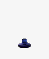 The Lucien candleholder, a small round piece made of cobalt glass with a narrow neck, is displayed against a plain white background.
