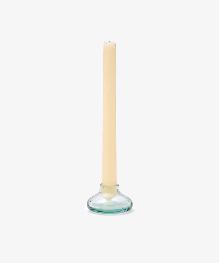 A beige taper candle stands in the Lucien bubble candleholder, Small—handblown in Morocco from recycled glass—set against a plain white background.