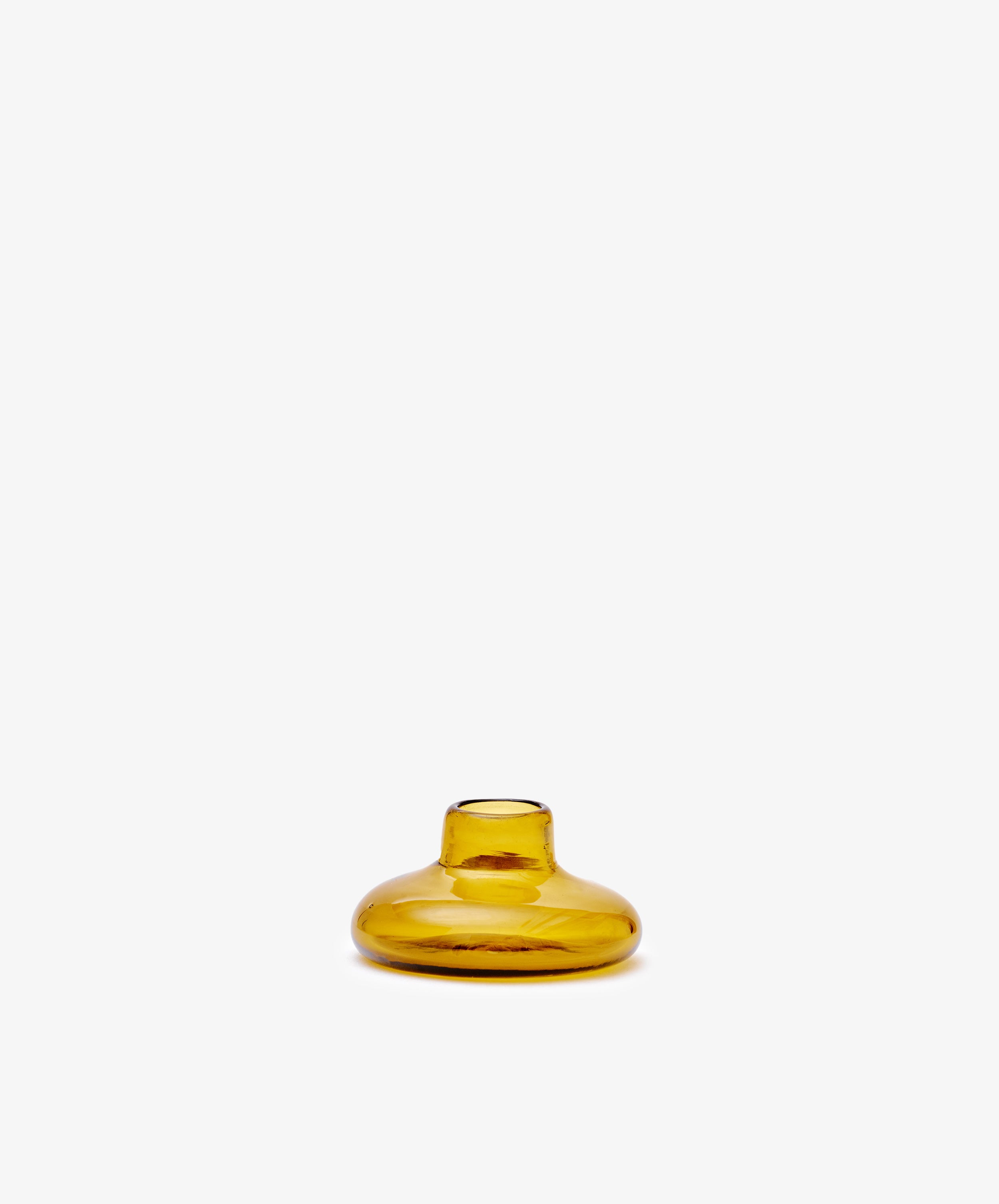 The Lucien candleholder is a small, round, amber glass vase with a short neck, handblown in Morocco from recycled glass candle holders and shown against a plain white background.