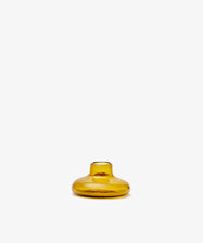 The Lucien candleholder is a small, round, amber glass vase with a short neck, handblown in Morocco from recycled glass candle holders and shown against a plain white background.