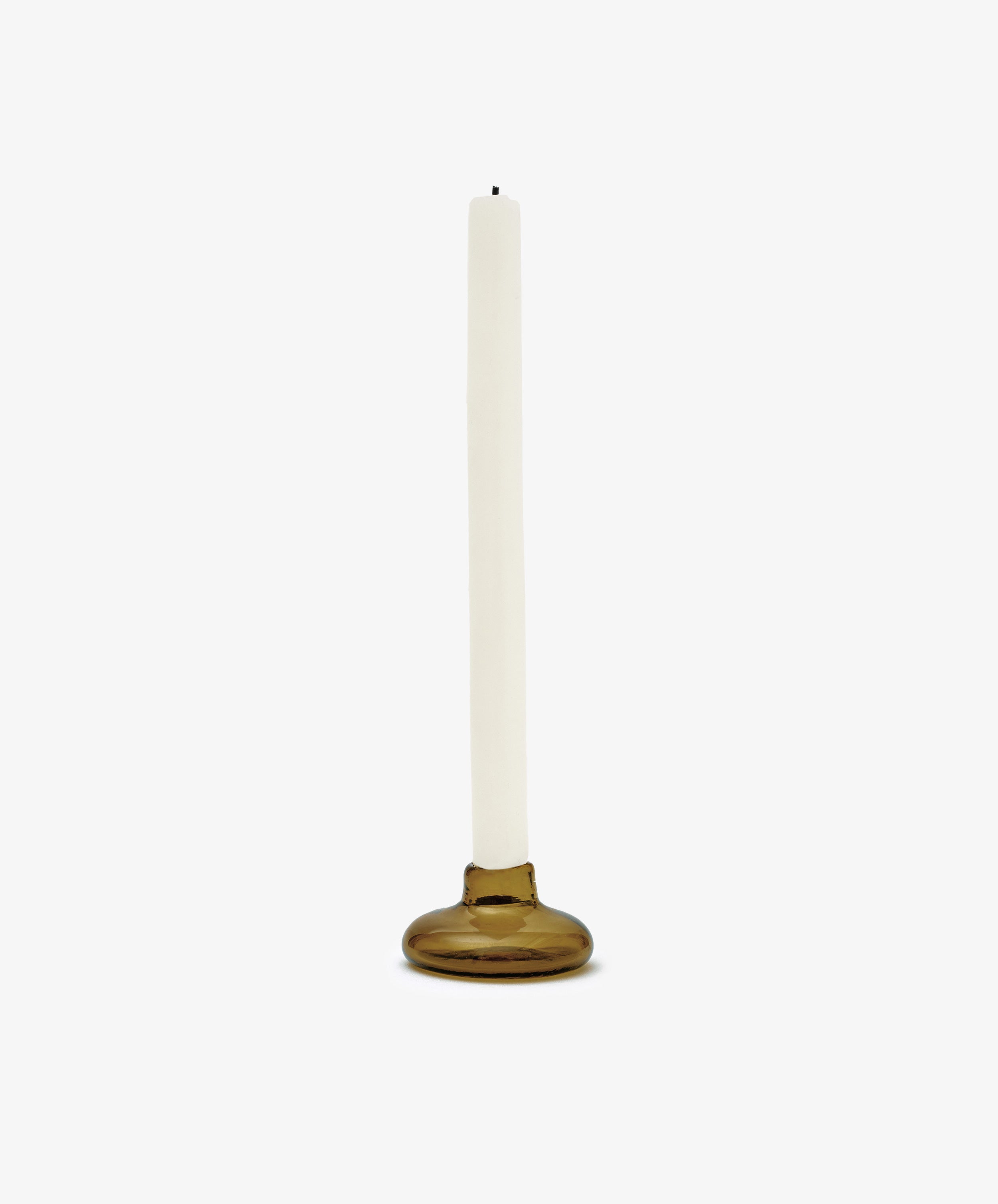 A white taper candle stands in the Lucien bubble candleholder, Small—a round, handblown brown glass holder from Morocco—set against a plain white background.