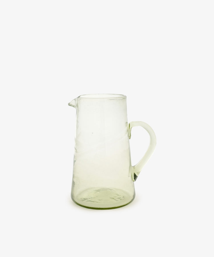 The Elodie Pitcher is a handblown Damascus glass piece with a handle and small spout, ideal for adding Mediterranean charm to your decor. Shown against a plain white background.