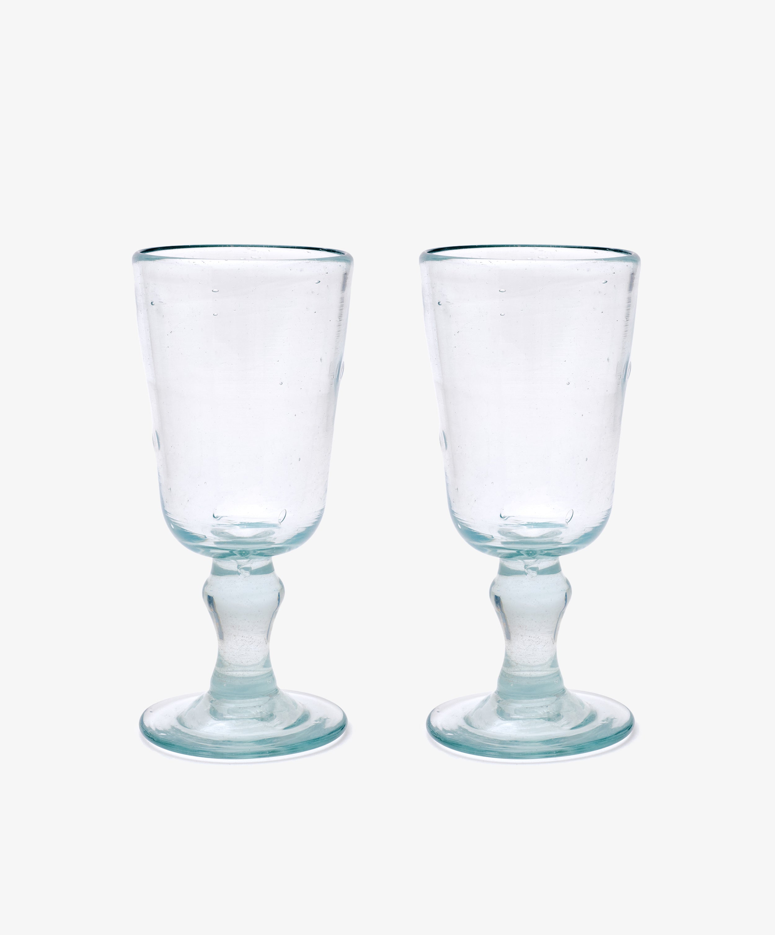 The Elodie Stemmed Wine Glass, Set of 6 features clear handmade glasses with short stems and round bases, shown side by side on a plain white background.