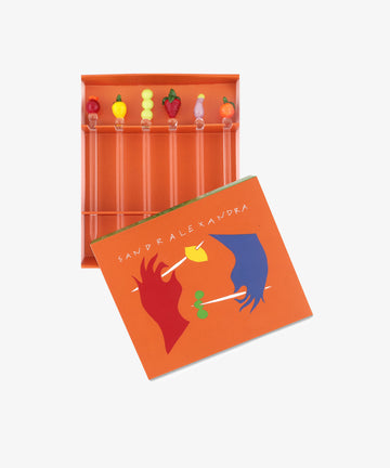 Groceries Cocktail and Nibble Sticks. Murano glass fruit and veg motif sticks in orange box with lid askew.