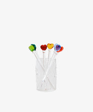 The Heart Cocktail and Nibble Sticks, Set of 6, features clear sticks topped with colorful glass hearts—green, red, yellow, orange, and purple—displayed in a transparent glass against a white background.
