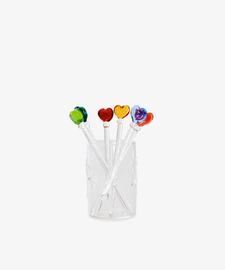 The Heart Cocktail and Nibble Sticks, Set of 6, features clear sticks topped with colorful glass hearts—green, red, yellow, orange, and purple—displayed in a transparent glass against a white background.