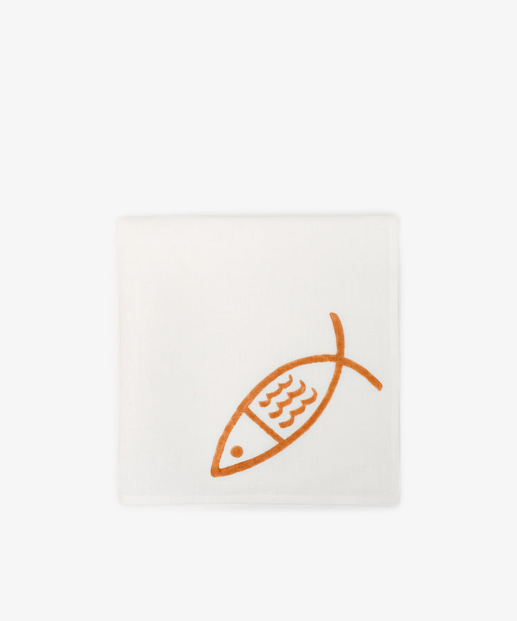 The Pezza Napkin, Set of 6, features white Italian linen with an orange fish outline in one corner. Ideal for coastal table settings, it brings a subtle seaside charm. Shown on a plain white background.