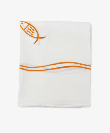 The Pezza Tablecloth is a folded white linen with a simple orange fish and wavy line design printed near one edgeâ€”ideal for coastal dÃ©cor.