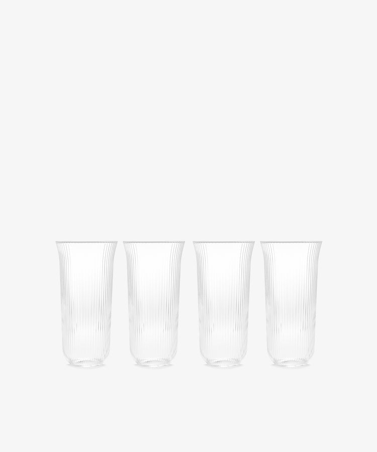 The Linea Ribbed Water Glass, Set of 4, features elegant ribbed glasses arranged on a white background, capturing the relaxed charm of coastal bistro style.