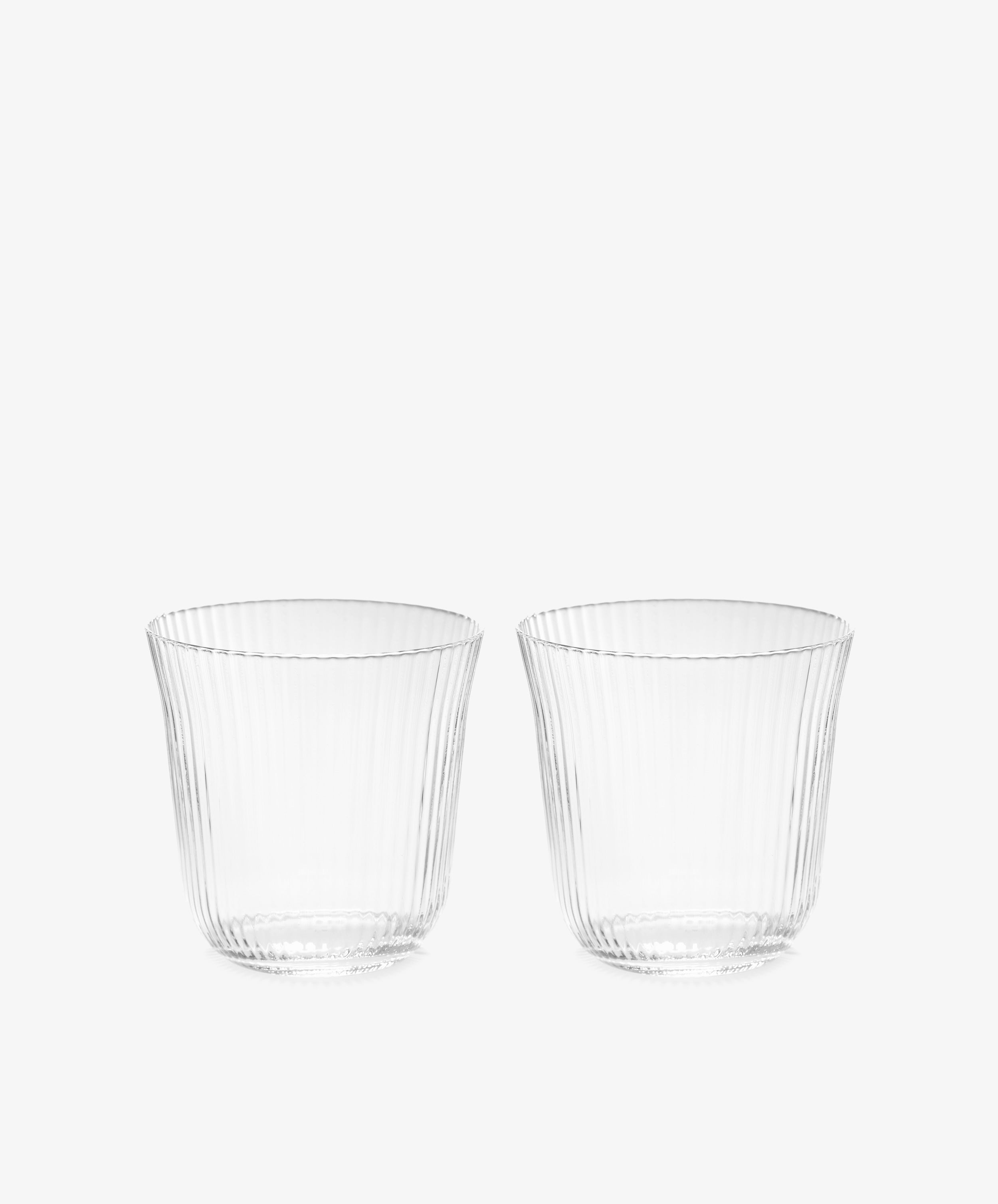 A set of four Linea Ribbed Tumblers, featuring a clear tapered design with ribbed detailing, is displayed side by side against a plain white background, highlighting their elegant restaurant-quality glassware.