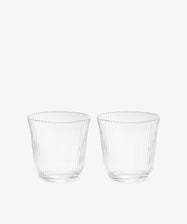 A set of four Linea Ribbed Tumblers, featuring a clear tapered design with ribbed detailing, is displayed side by side against a plain white background, highlighting their elegant restaurant-quality glassware.