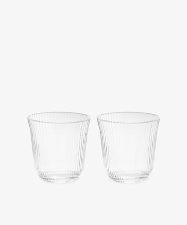 A set of four Linea Ribbed Tumblers, featuring a clear tapered design with ribbed detailing, is displayed side by side against a plain white background, highlighting their elegant restaurant-quality glassware.