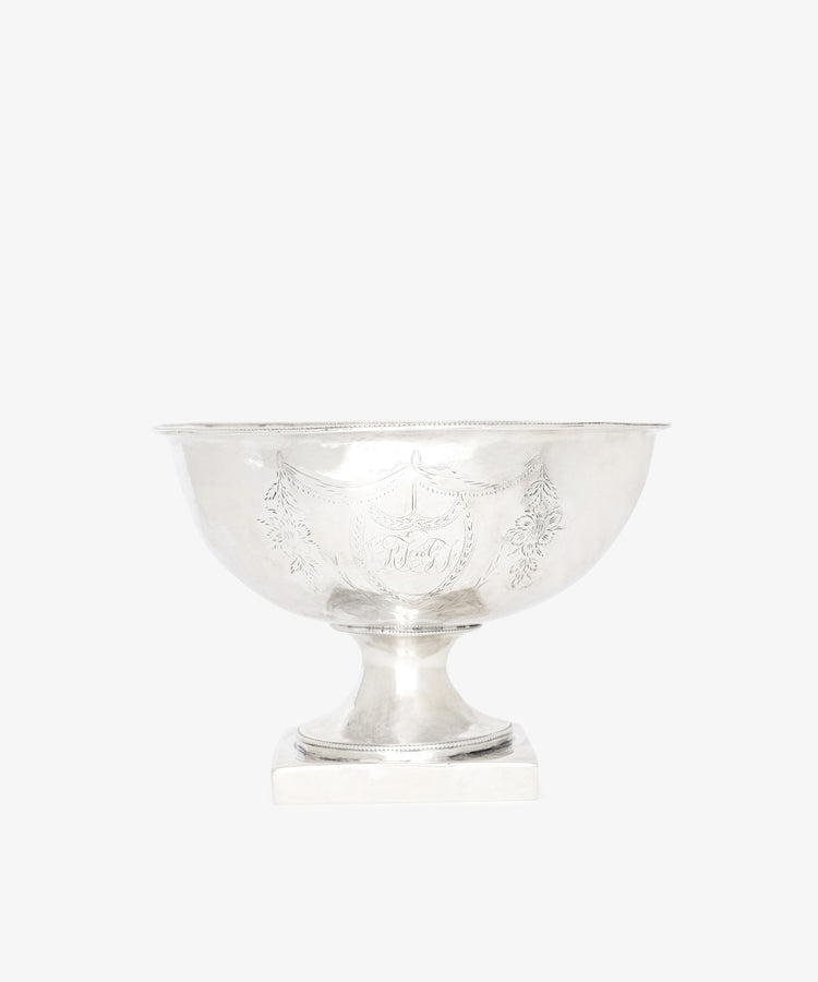 The Vintage Silver Bowl, featuring engraved decorative patterns and a square base, is elegantly displayed against a plain white background.