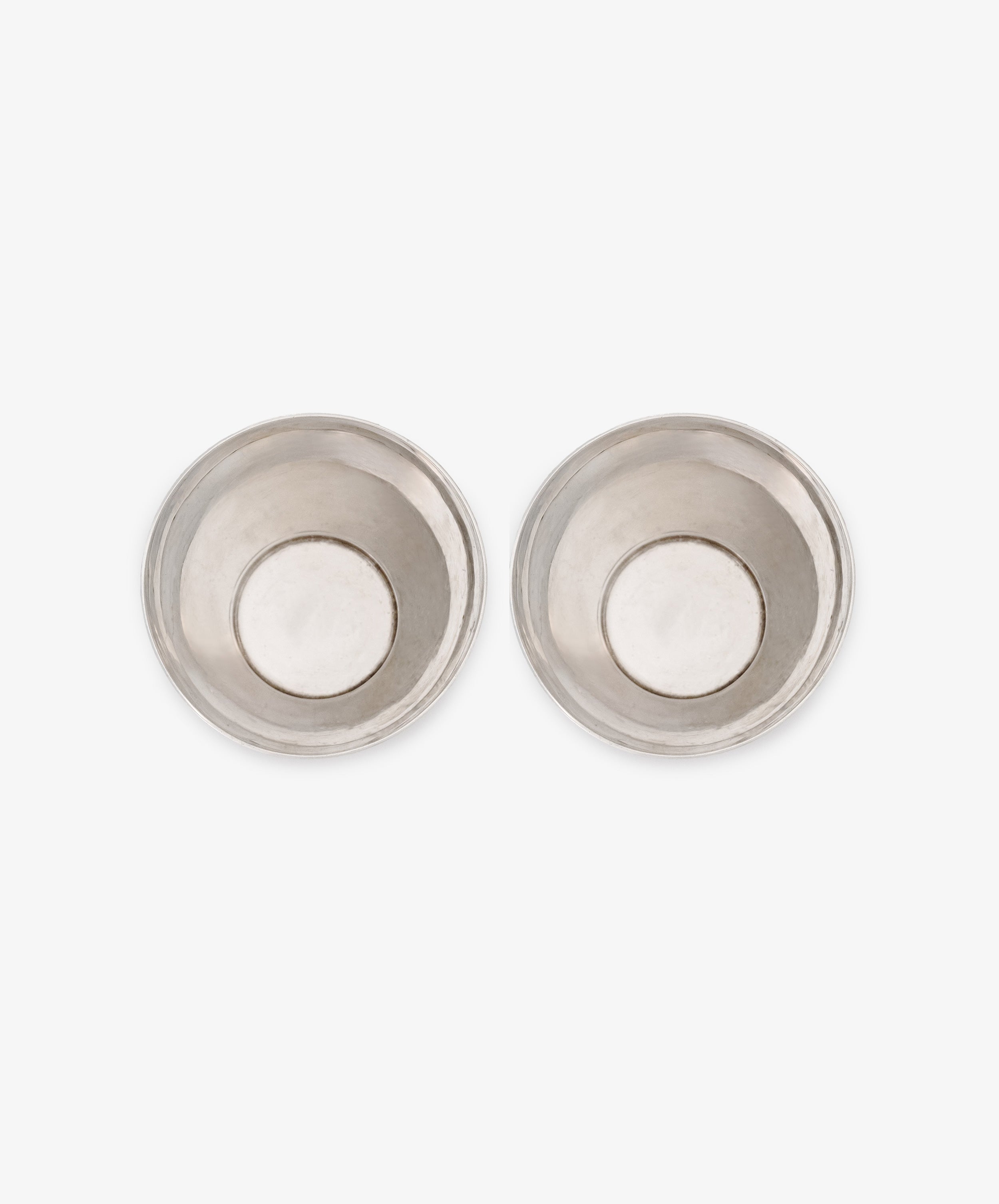 A vintage pair of silver beakers, round and shallow, are displayed side by side on a white background.