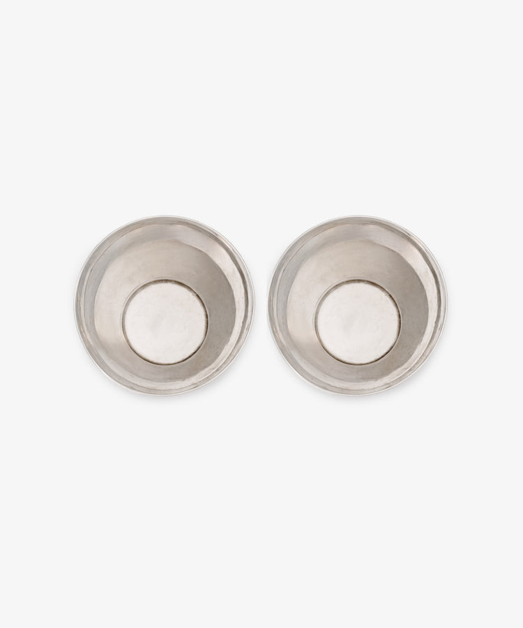 A vintage pair of silver beakers, round and shallow, are displayed side by side on a white background.