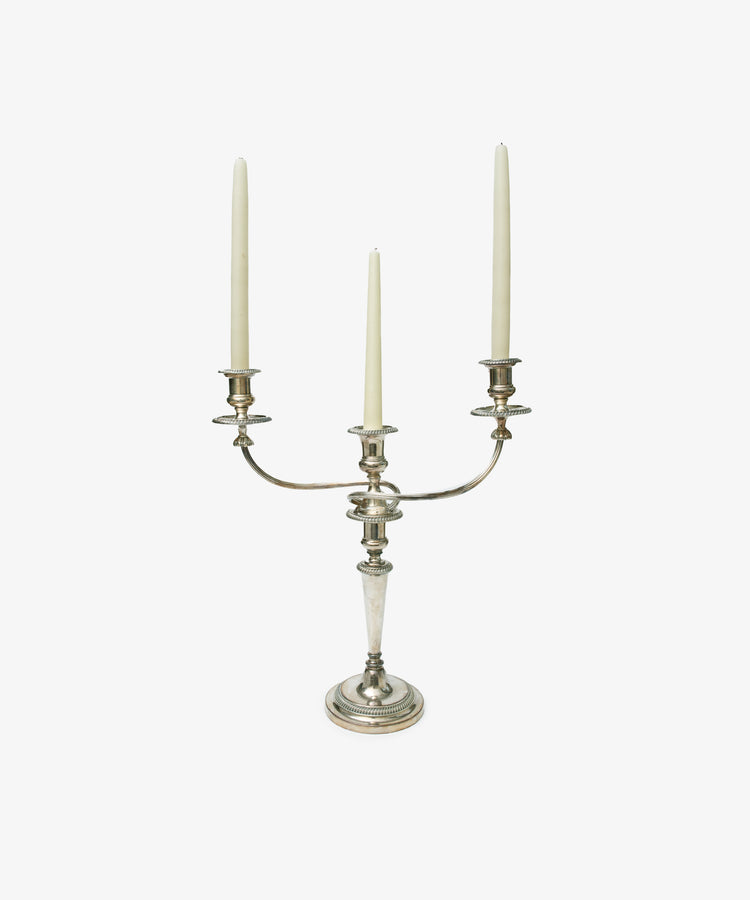 A set of 2 vintage silver-plated Sheffield Plate candelabra, each with three arms holding white taper candles, is displayed elegantly against a plain white background.